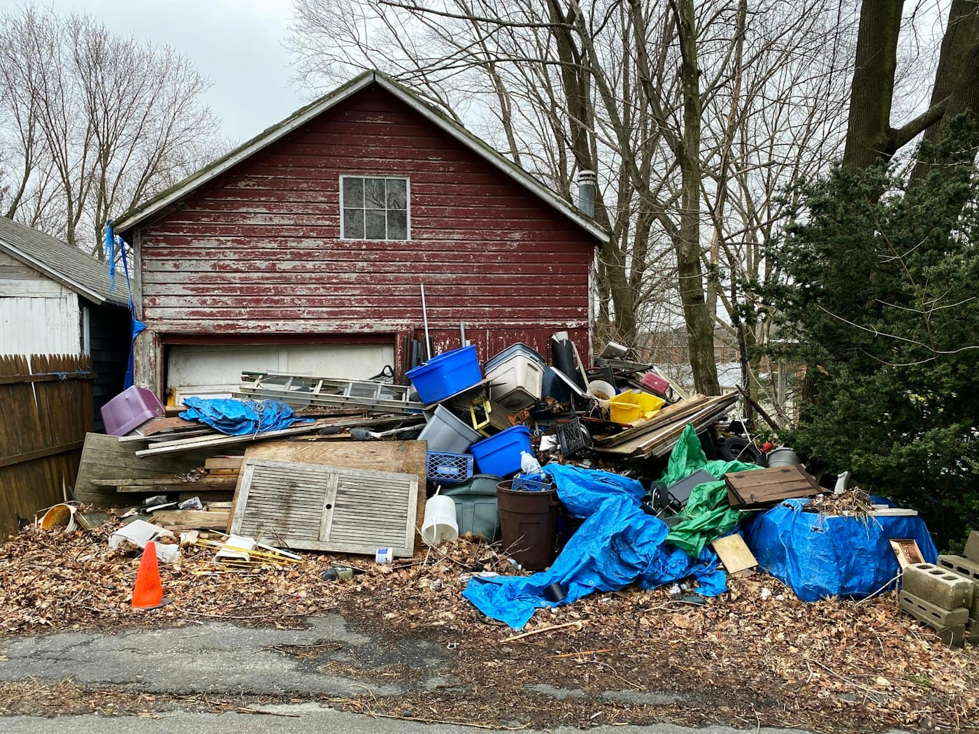 Household clutter and unwanted materials piled outside a garage for a cleanout